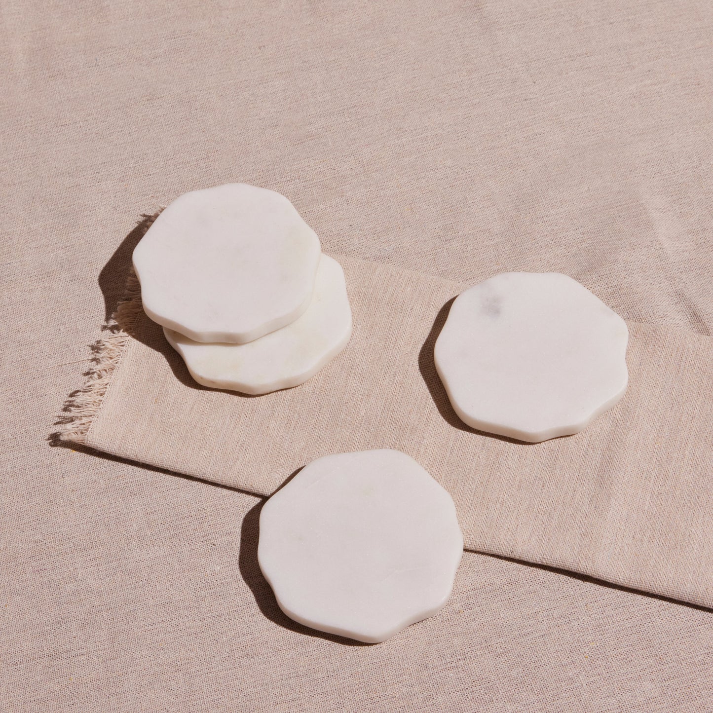 Set of four white, handmade marble beverage coasters from Honduras.