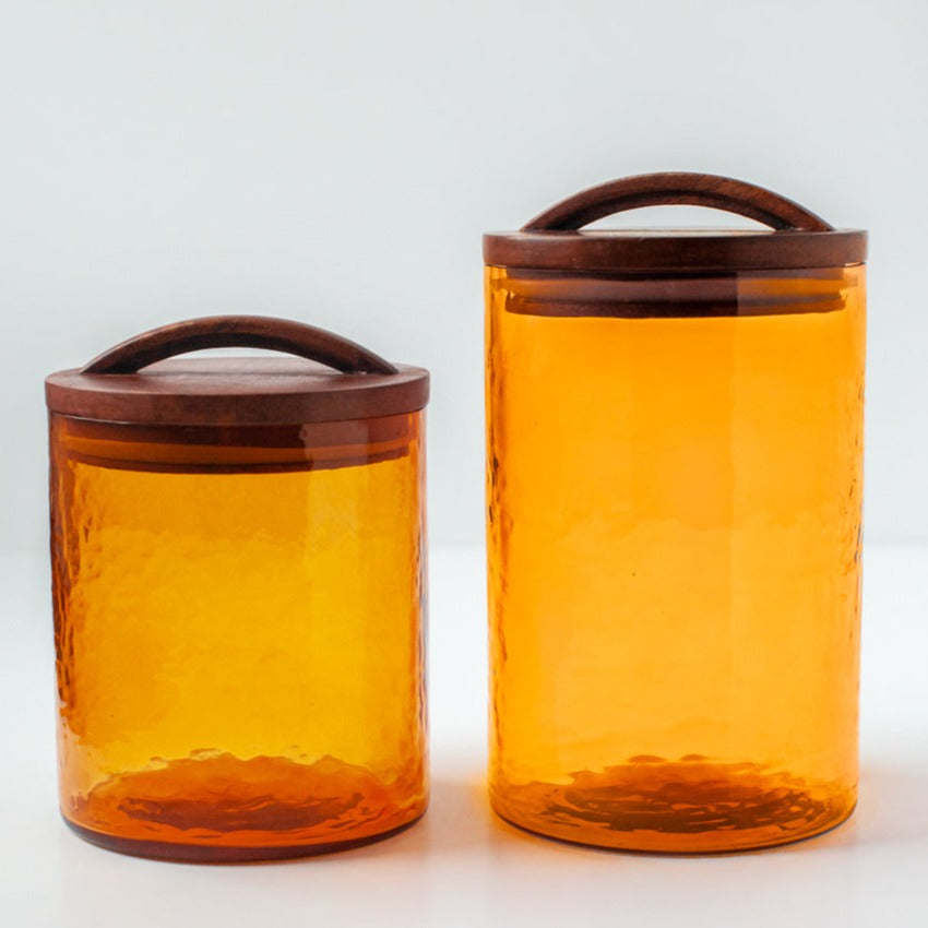 Handblown glass canisters in the color of amber. Wooden lids are hand carved.