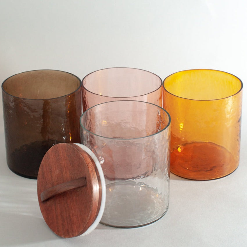 Handblown glass canisters in 4 colors, amber, smoke, blush, and clear. Wooden lids are hand carved.