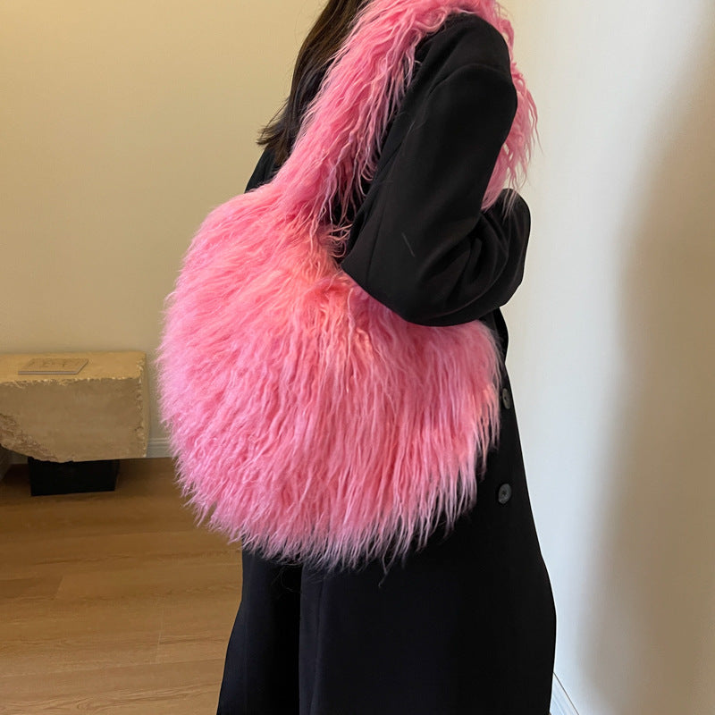 A heart-shaped plush shoulder bag, a stylish and high-quality women's luxury handbag, perfect for winter, featuring large capacity and personalized design – an ideal gift. Here it is in soft pink.